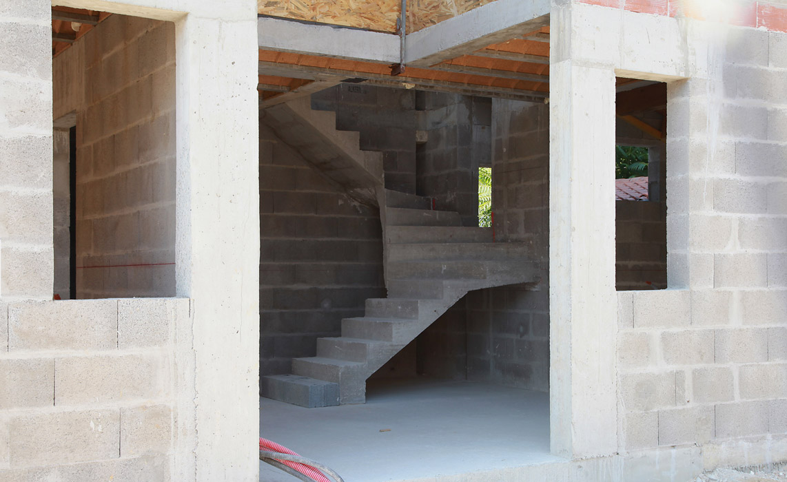 Travaux de construction dans une maison moderne, murs et structures en cours de réalisation.