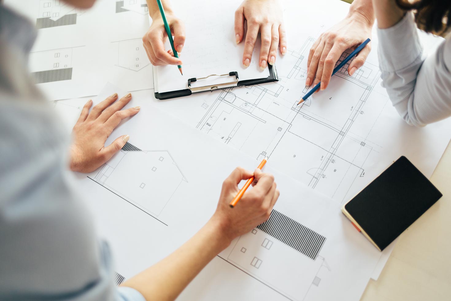 Architecte travaillant sur des plans de bâtiment sur deux écrans en bureau.